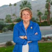 Candidate in blue jacket with arms crossed